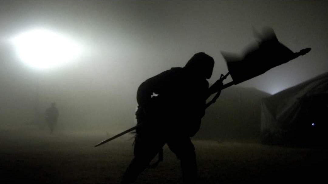 Militar portando el estandarte de la unidad entre la niebla