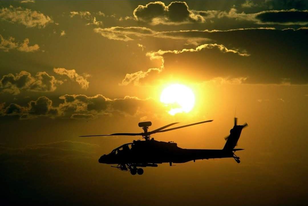 Helicóptero militar sobrevolando al atardecer