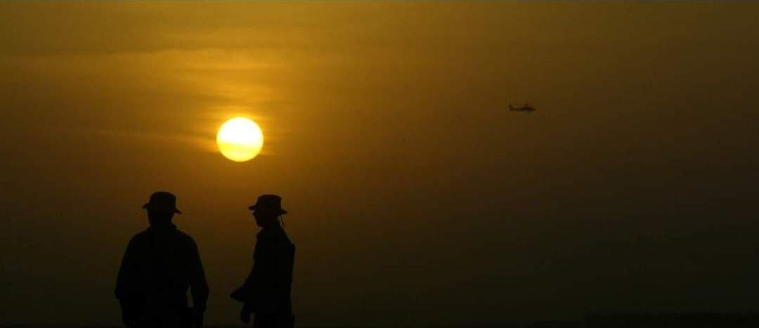 Patrulla militar en silueta al atardecer