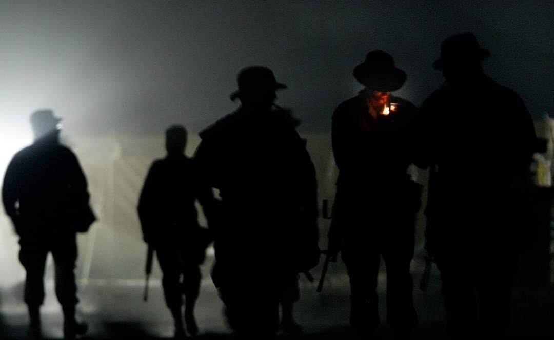 Unidad militar avanzando entre la niebla al amanecer